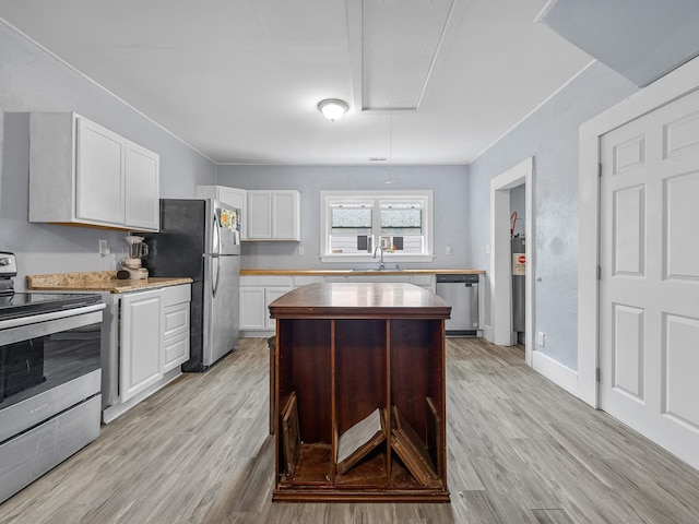 24 Oak St, Spartanburg, SC 29306 - kitchen with stainless steel appliances, light wood-style floors, white cabinetry, and wooden counters