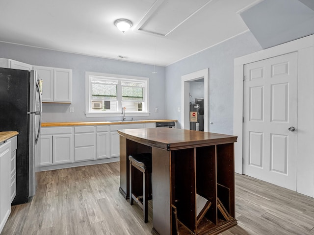 24 Oak St, Spartanburg, SC 29306 - kitchen with butcher block countertops, freestanding refrigerator, light wood finished floors, and water heater