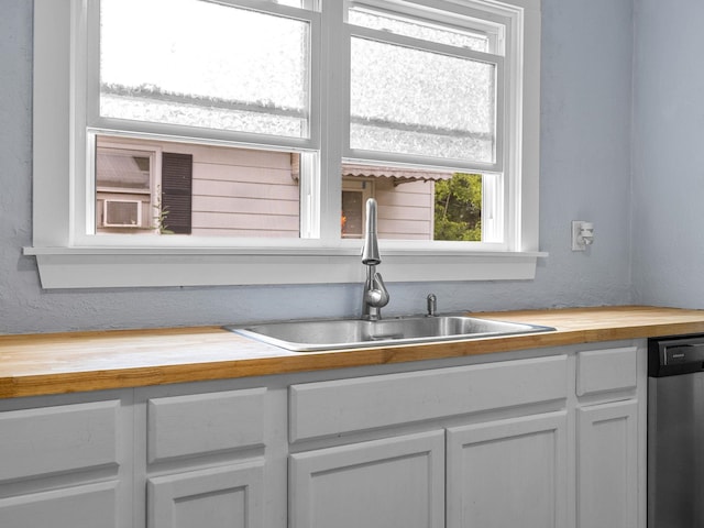 24 Oak St, Spartanburg, SC 29306 - kitchen featuring butcher block counters, dishwasher, white cabinetry, and cooling unit