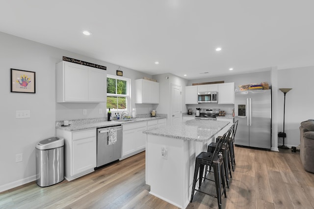 2097 Evanston Dr, Wellford, SC 29385 - kitchen featuring appliances with stainless steel finishes, white cabinetry, a breakfast bar, light wood-type flooring, and recessed lighting