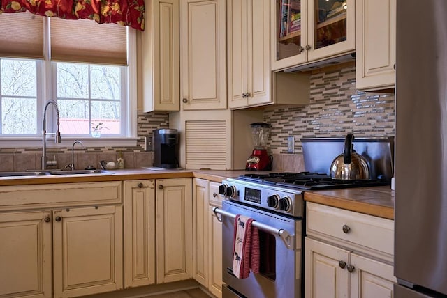 226 John Smith Rd, Columbus, NC 28722 - kitchen with appliances with stainless steel finishes, cream cabinetry, backsplash, and glass insert cabinets