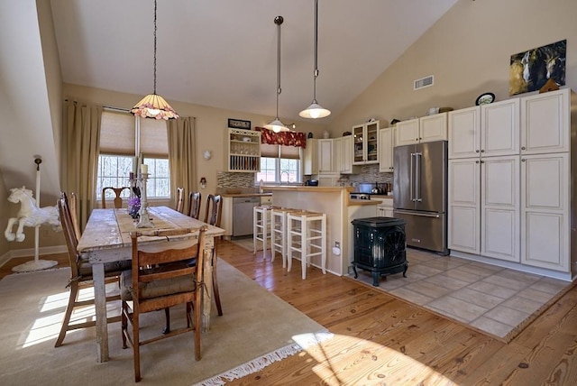 226 John Smith Rd, Columbus, NC 28722 - dining space featuring light wood-type flooring, high vaulted ceiling, and plenty of natural light