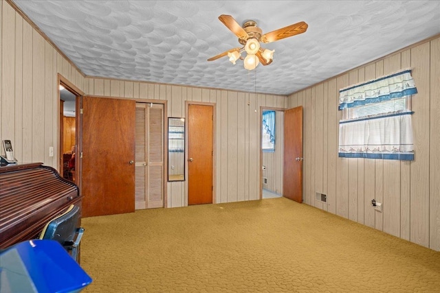 195 Seigle Dr, Inman, SC 29349 - bedroom featuring wood walls, carpet, a ceiling fan, and multiple closets