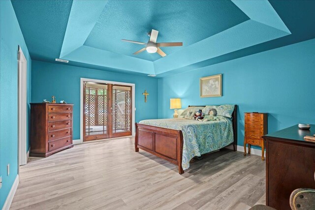 3881 New Cut Rd, Inman, SC 29349 - bedroom featuring a raised ceiling, wood finished floors, access to outside, a textured ceiling, and a ceiling fan