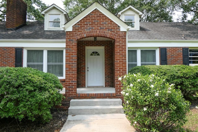 4421 New Cut Rd, Inman, SC 29349 - view of exterior entry with brick siding, a chimney, and roof with shingles
