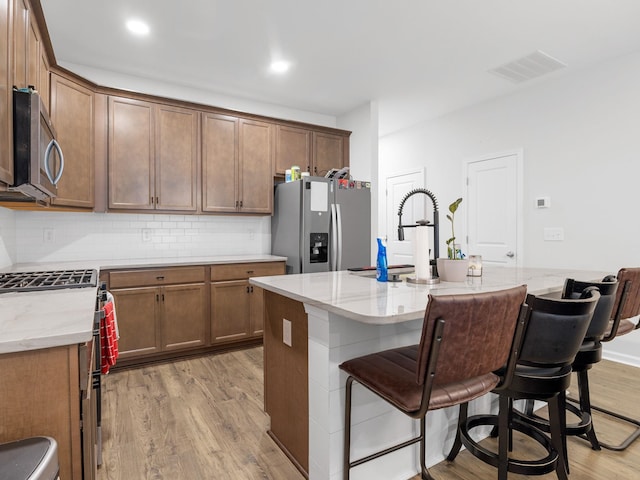 115 Turfway Dr, Greer, SC 29651 - kitchen featuring stainless steel appliances, light wood-style floors, tasteful backsplash, light stone counters, and recessed lighting