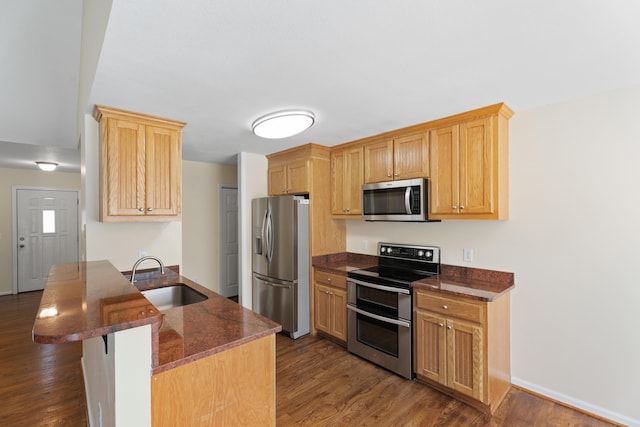 719 S Bomar Ave, Landrum, SC 29356 - kitchen featuring stainless steel appliances, dark wood finished floors, a kitchen breakfast bar, dark stone counters, and a peninsula