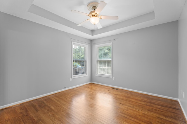 719 S Bomar Ave, Landrum, SC 29356 - unfurnished room featuring a raised ceiling, wood finished floors, and a ceiling fan