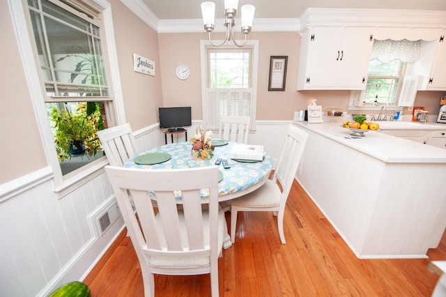 147 Hillbrook Dr, Spartanburg, SC 29307 - dining room with light wood finished floors, wainscoting, crown molding, a chandelier, and a decorative wall