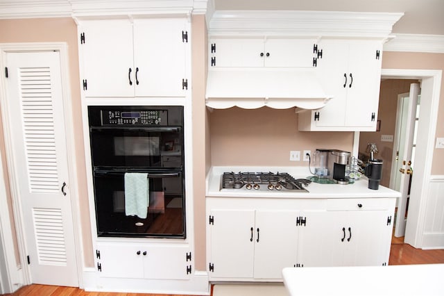 147 Hillbrook Dr, Spartanburg, SC 29307 - kitchen with stainless steel gas stovetop, light countertops, white cabinetry, crown molding, and light wood-style floors