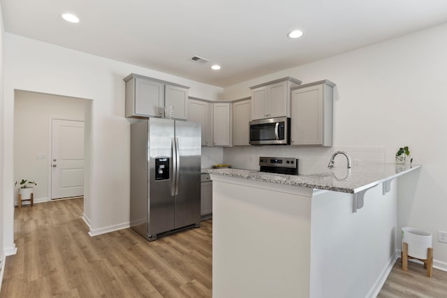 3008 Olivette Pl, Duncan, SC 29334 - kitchen with appliances with stainless steel finishes, gray cabinetry, a peninsula, light wood finished floors, and recessed lighting