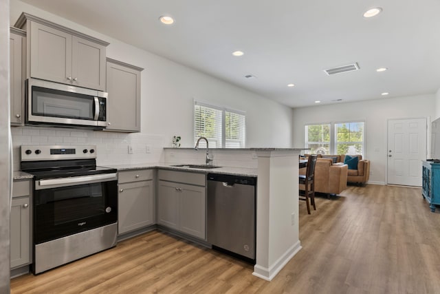 3008 Olivette Pl, Duncan, SC 29334 - kitchen with appliances with stainless steel finishes, gray cabinets, a peninsula, light wood finished floors, and open floor plan