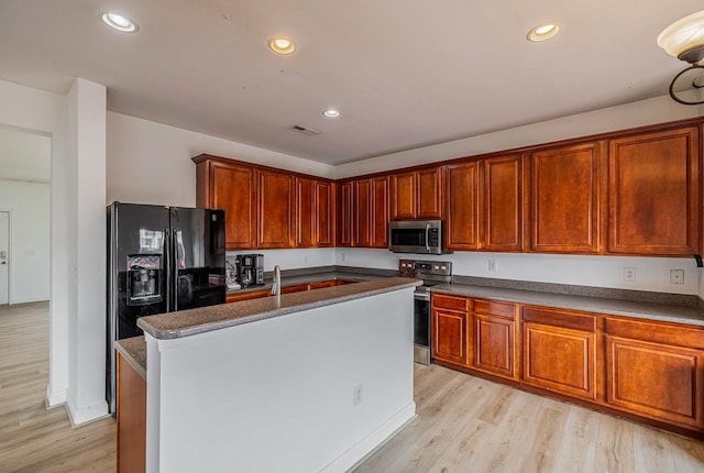 811 S Edisto River Dr, Roebuck, SC 29376 - kitchen featuring appliances with stainless steel finishes, light wood finished floors, recessed lighting, dark countertops, and a center island with sink