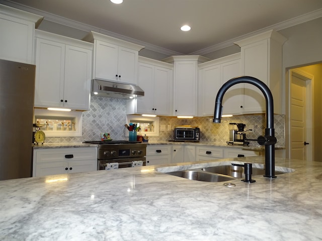 811 White Magnolia Dr, Inman, SC 29349 - kitchen featuring appliances with stainless steel finishes, under cabinet range hood, white cabinetry, backsplash, and light stone counters