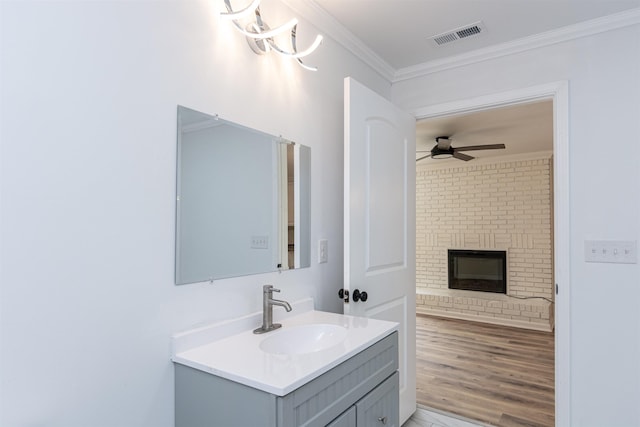 1230 Edgewood Ave, Spartanburg, SC 29301 - bathroom featuring vanity, a ceiling fan, crown molding, a brick fireplace, and wood finished floors