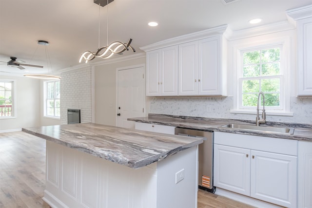 1230 Edgewood Ave, Spartanburg, SC 29301 - kitchen with stainless steel dishwasher, ornamental molding, healthy amount of natural light, a kitchen island, and white cabinetry