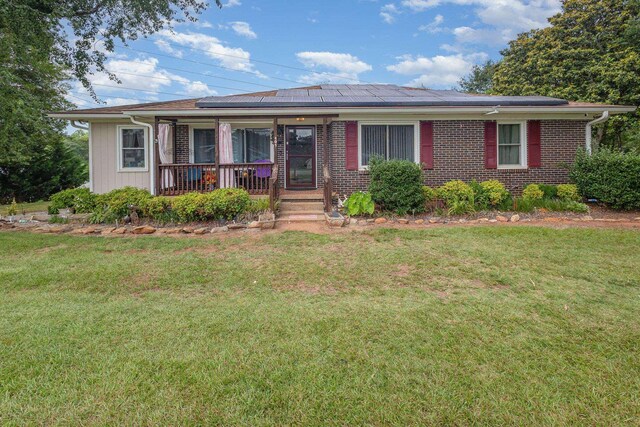 101 Jordan Rd, Lyman, SC 29365 - view of front of property featuring covered porch, solar panels, a front yard, and brick siding