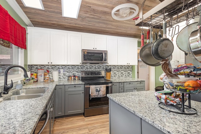 101 Jordan Rd, Lyman, SC 29365 - kitchen with stainless steel appliances, gray cabinets, light wood-style floors, decorative backsplash, and light stone counters