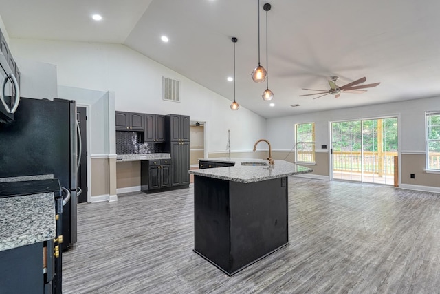 203 Palmetto Dr, Greer, SC 29651 - kitchen featuring ceiling fan, light wood-style floors, a kitchen island with sink, tasteful backsplash, and open floor plan