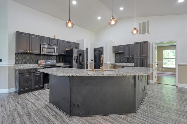 203 Palmetto Dr, Greer, SC 29651 - kitchen with appliances with stainless steel finishes, light wood-style floors, decorative backsplash, a large island with sink, and high vaulted ceiling