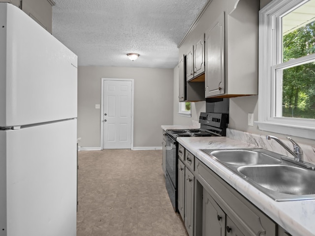 126 Loblolly Dr, Wellford, SC 29385 - kitchen featuring freestanding refrigerator, electric range oven, light countertops, a textured ceiling, and healthy amount of natural light