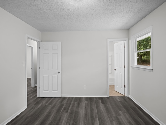 126 Loblolly Dr, Wellford, SC 29385 - unfurnished bedroom featuring dark wood-style floors, a textured ceiling, and ensuite bath