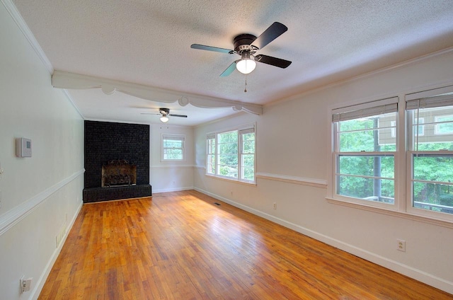 120 Branch St, Campobello, SC 29322 - unfurnished living room with a textured ceiling, ornamental molding, light wood-style floors, a ceiling fan, and a brick fireplace