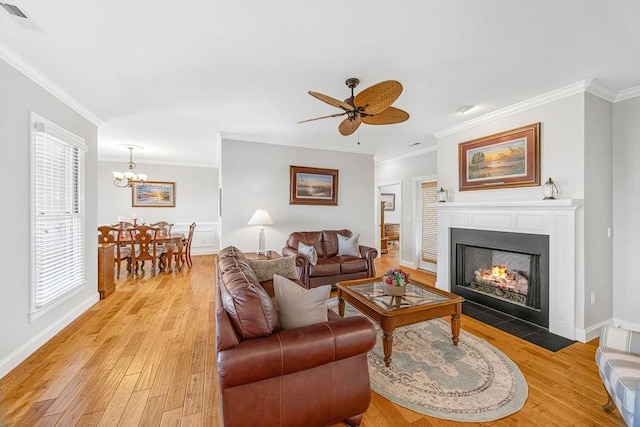 325 Reflection Dr, Lyman, SC 29365 - living area with ornamental molding, light wood-style flooring, a chandelier, ceiling fan, and a fireplace with flush hearth