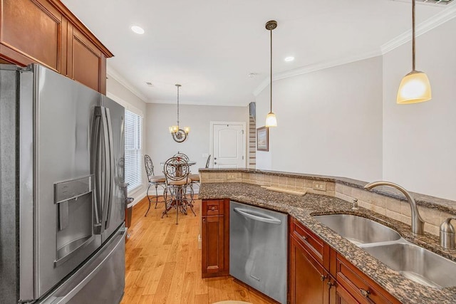 325 Reflection Dr, Lyman, SC 29365 - kitchen with stainless steel appliances, ornamental molding, light wood finished floors, hanging light fixtures, and dark stone countertops