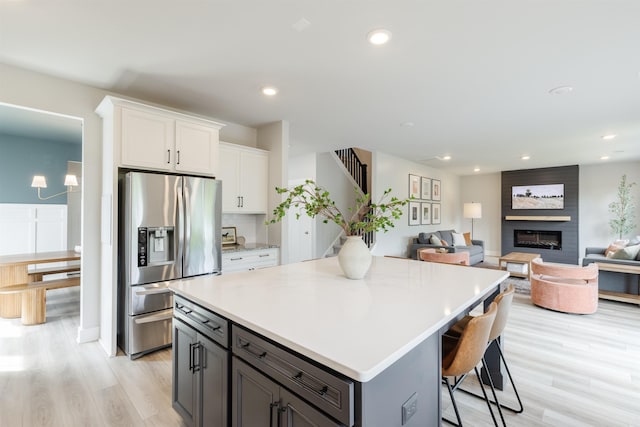 738 Judah Dr, Moore, SC 29369 - kitchen featuring stainless steel refrigerator with ice dispenser, white cabinets, a center island, light wood finished floors, and light countertops