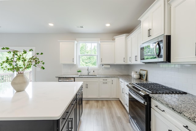 738 Judah Dr, Moore, SC 29369 - kitchen with stainless steel appliances, white cabinets, decorative backsplash, recessed lighting, and light stone counters
