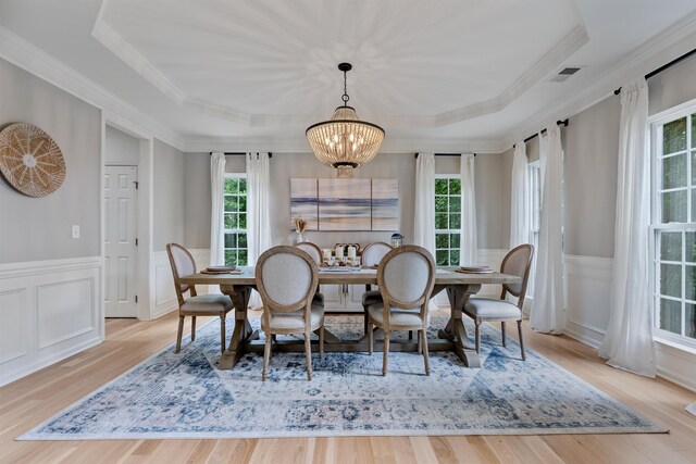 5 Modesto Ln, Simpsonville, SC 29681 - dining area featuring a tray ceiling, crown molding, a chandelier, wainscoting, and wood finished floors