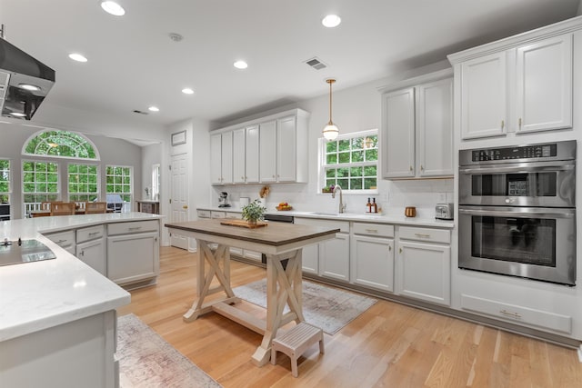 5 Modesto Ln, Simpsonville, SC 29681 - kitchen featuring stainless steel double oven, light countertops, decorative backsplash, recessed lighting, and hanging light fixtures