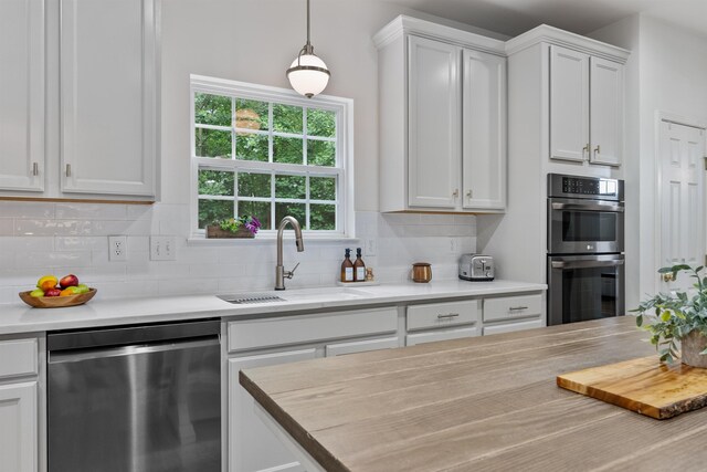 5 Modesto Ln, Simpsonville, SC 29681 - kitchen with stainless steel appliances, decorative backsplash, white cabinets, and decorative light fixtures