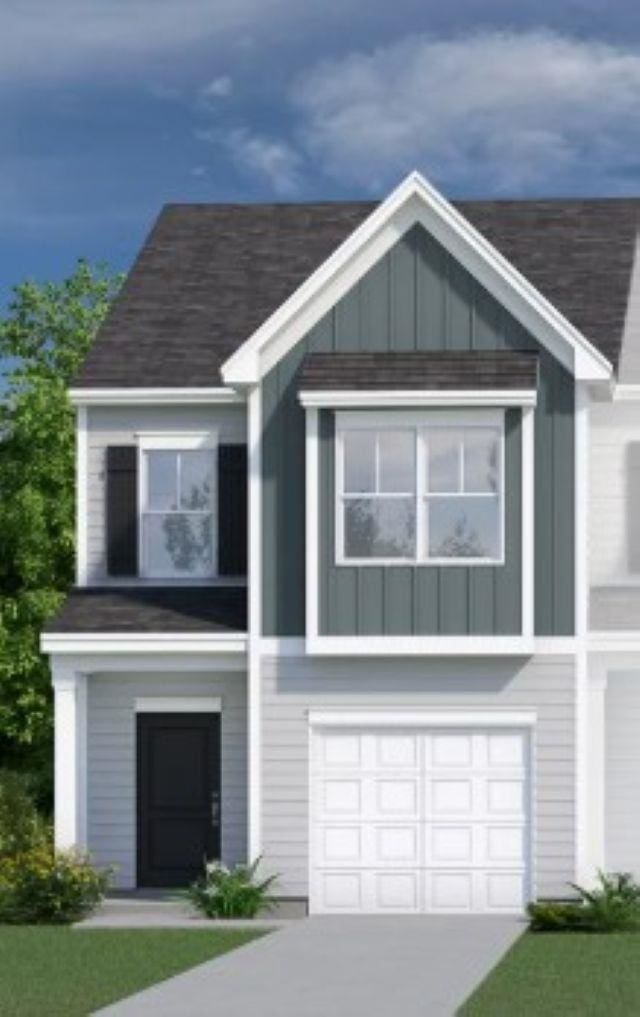 2009 Hillman Way, Roebuck, SC 29376 - view of front of home with board and batten siding, an attached garage, and driveway