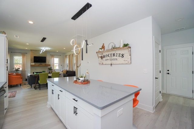 125 Patton St, Fountain Inn, SC 29644 - kitchen featuring open floor plan, light wood-type flooring, white cabinets, hanging light fixtures, and a kitchen island