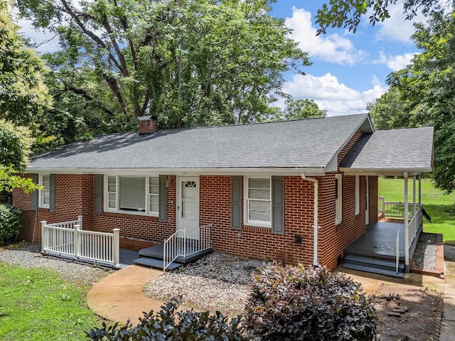 177 Continental Dr, Spartanburg, SC 29302 - view of front facade with covered porch, brick siding, roof with shingles, and a chimney