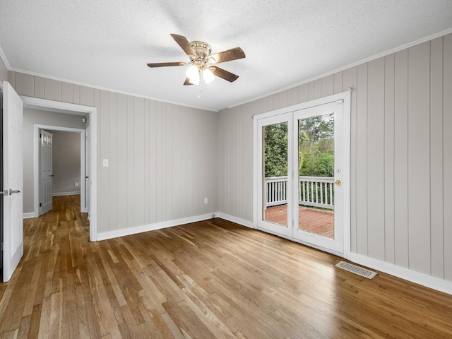 177 Continental Dr, Spartanburg, SC 29302 - spare room featuring crown molding, wood-type flooring, a ceiling fan, a textured ceiling, and wooden walls