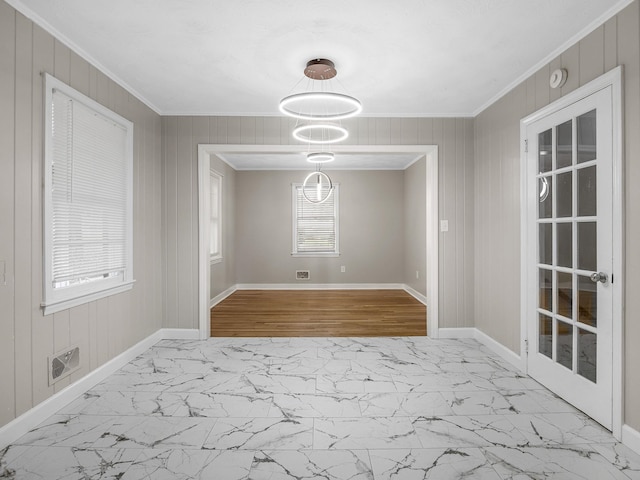 177 Continental Dr, Spartanburg, SC 29302 - unfurnished dining area with ornamental molding, marble look tile flooring, and wooden walls