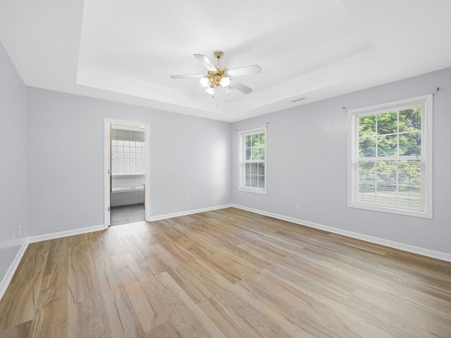 177 Continental Dr, Spartanburg, SC 29302 - spare room featuring a tray ceiling, ceiling fan, and light wood finished floors