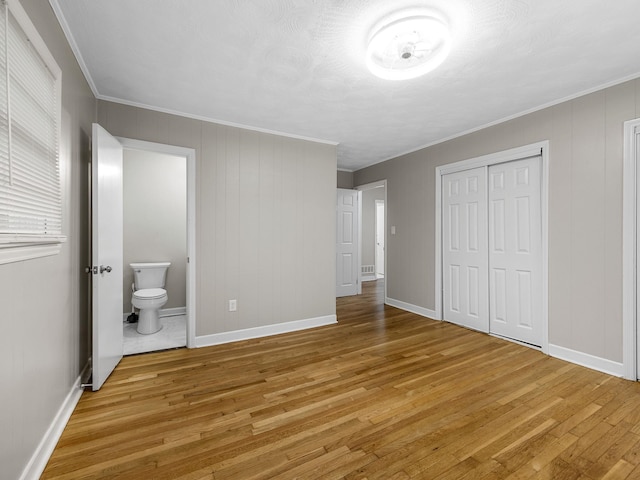 177 Continental Dr, Spartanburg, SC 29302 - unfurnished bedroom featuring light wood-style floors, a closet, ornamental molding, and connected bathroom