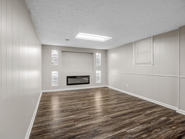 177 Continental Dr, Spartanburg, SC 29302 - unfurnished living room featuring dark wood-style floors, a glass covered fireplace, and a textured ceiling