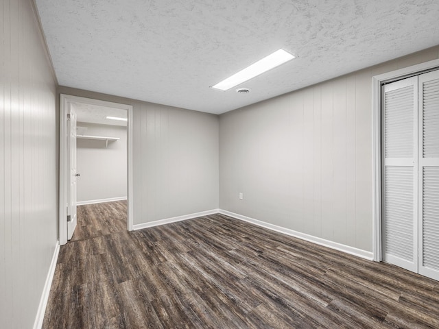 177 Continental Dr, Spartanburg, SC 29302 - unfurnished bedroom with dark wood-style flooring, a closet, and a textured ceiling