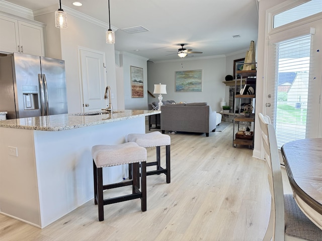 2601 Karkinnen Way, Moore, SC 29369 - kitchen with stainless steel refrigerator with ice dispenser, ceiling fan, light wood-type flooring, light stone counters, and ornamental molding