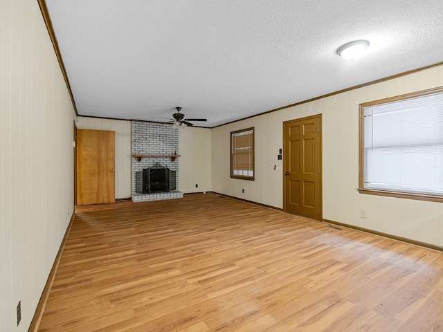 308 Pine Lake Ct, Spartanburg, SC 29301 - unfurnished living room featuring ornamental molding, ceiling fan, light wood finished floors, a brick fireplace, and a textured ceiling