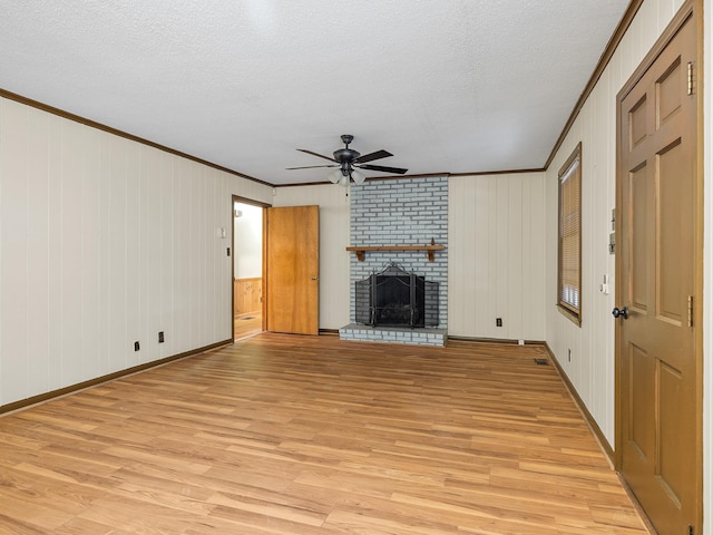 308 Pine Lake Ct, Spartanburg, SC 29301 - unfurnished living room with ornamental molding, ceiling fan, light wood finished floors, a fireplace, and a textured ceiling