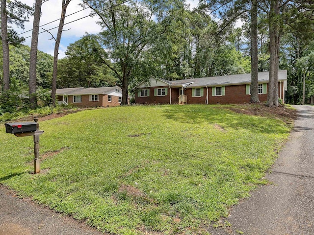 308 Pine Lake Ct, Spartanburg, SC 29301 - ranch-style home with brick siding, a front yard, asphalt driveway, and view of scattered trees