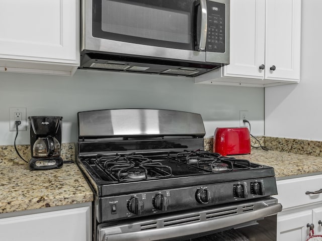 234 Page Creek Blvd, Landrum, SC 29356 - kitchen with gas stove, stainless steel microwave, white cabinetry, and light stone counters