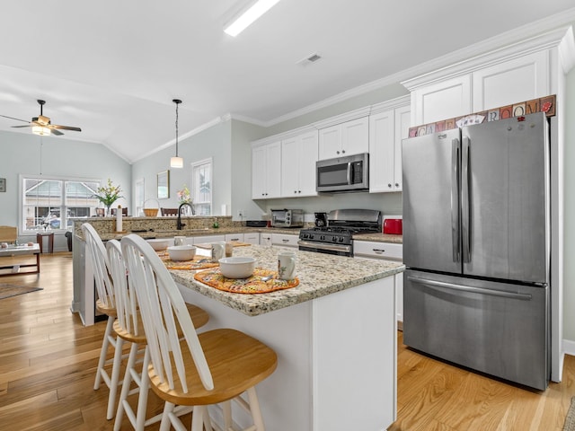 234 Page Creek Blvd, Landrum, SC 29356 - kitchen with stainless steel appliances, ceiling fan, white cabinetry, light wood-style floors, and vaulted ceiling