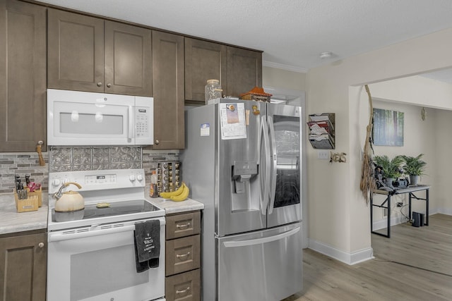 208 Kenneth Dr, Boiling Springs, SC 29316 - kitchen with white appliances, light wood-style flooring, decorative backsplash, light countertops, and a textured ceiling